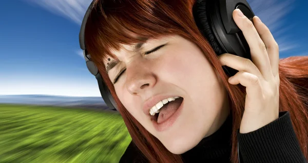 Linda pelirroja disfrutando de música — Foto de Stock