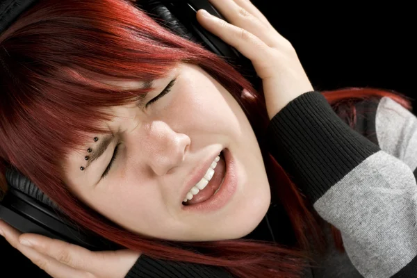 Girl holding headphones and singing — Stock Photo, Image