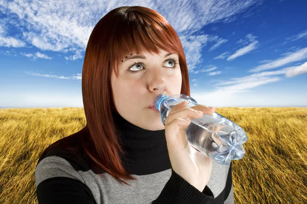 赤毛の女の子は、水を飲む — ストック写真