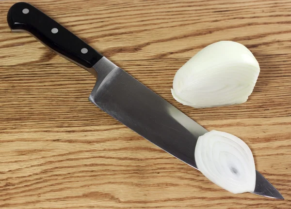 stock image An onion sliced by a chef's knife