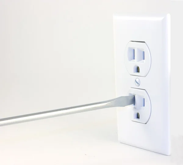 stock image A screwdriver going into an outlet