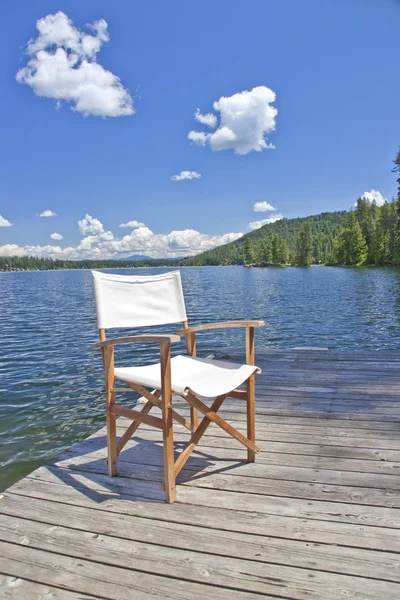 Una sedia sul molo di un bellissimo lago — Foto Stock