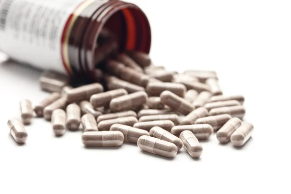 Pílulas medicinais derramadas para fora do frasco — Fotografia de Stock