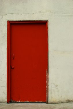Kırmızı kapılı bir off-beyaz sıva duvar