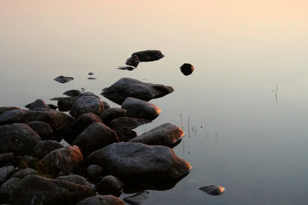 stock image Stones in calm sunset water