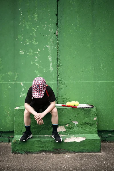 Грустный юный теннисист отдыхает — стоковое фото