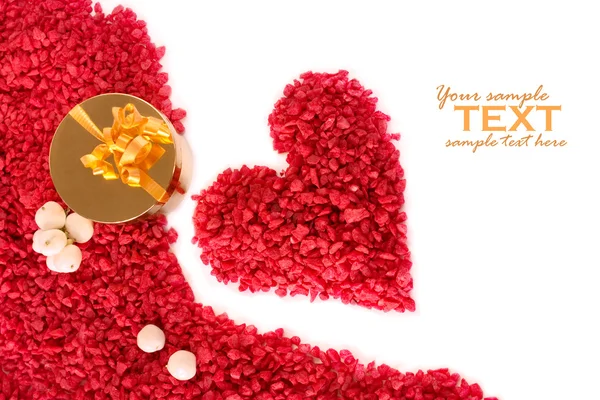 Valentijn hart gemaakt van rode steentjes met gouden geschenkdoos — Stockfoto
