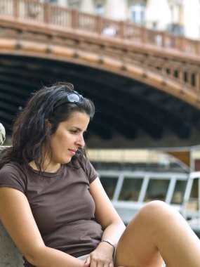 Beautiful girl posing in a bridge over the Seine river in Paris clipart