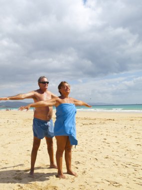 Senior Couple having fun in the beach clipart