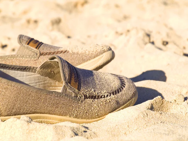 Old shoes in the sand — Stock Photo, Image