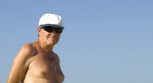 Starší muž relaxační v beach — Stock fotografie