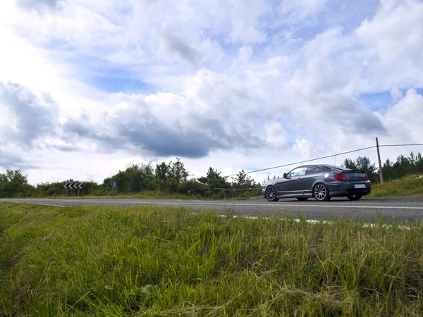 Sport auto geparkeerd in een platteland weg — Stockfoto