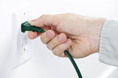 Hand removing plug from outlet clipart