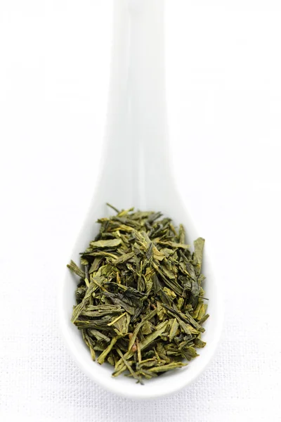 Droge groene theebladeren in een lepel — Stockfoto