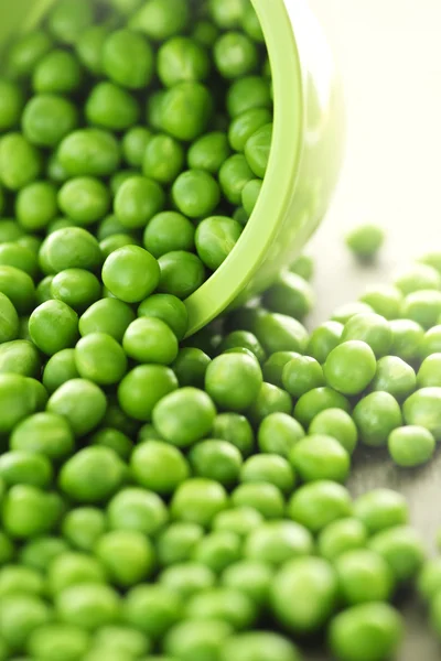 Spilled bowl of green peas — Stock Photo, Image