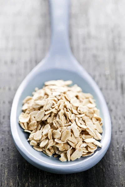 Spoon of uncooked rolled oats — Stock Photo, Image