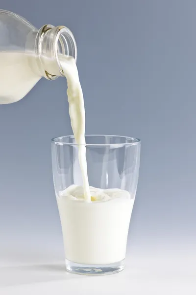 Melk in glas gieten — Stockfoto