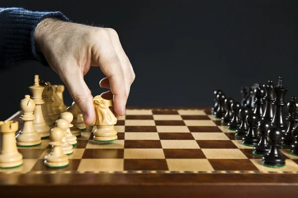 Hand moving knight on chess board — Stock Photo, Image