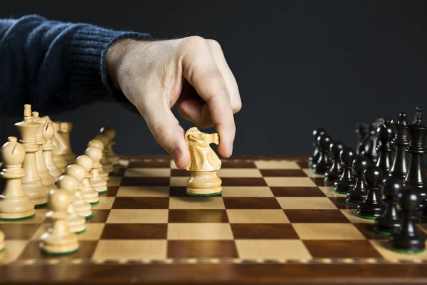 Hand moving knight on chess board — Stock Photo, Image