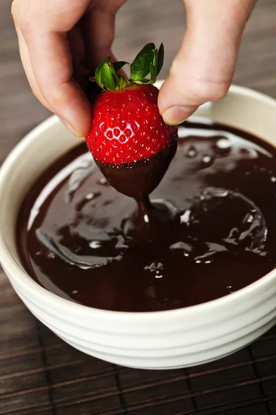 Hand dipping strawberry in chocolate — Stock Photo, Image