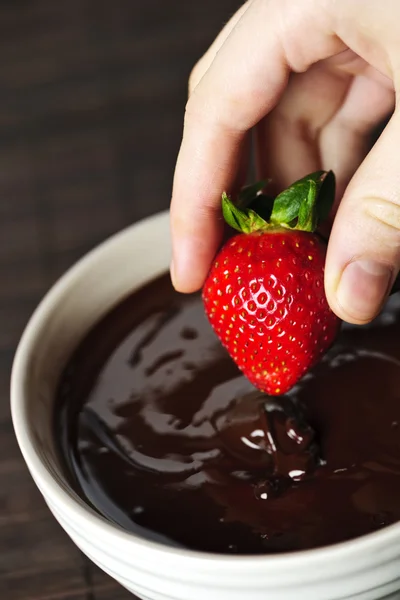 Hand dipping strawberry in chocolate — Stock Photo, Image