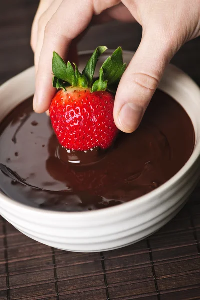 Ręka, zanurzenie truskawki w czekoladzie — Zdjęcie stockowe