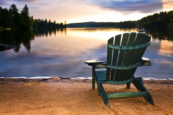 Sedia in legno al tramonto sulla spiaggia — Foto Stock