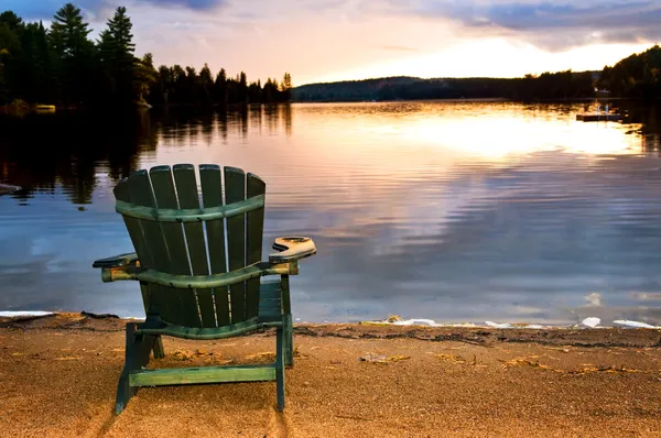 Дерев'яний стілець на заході сонця на пляжі — стокове фото