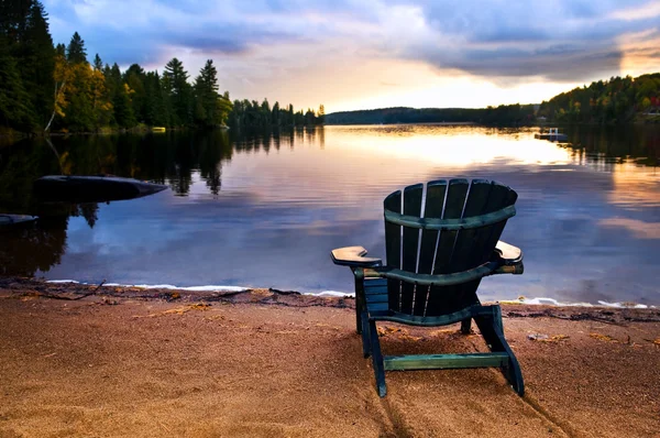 Dřevěná židle při západu slunce na pláži — Stock fotografie