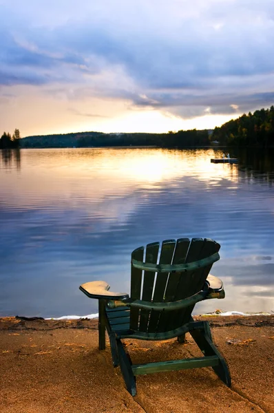 Деревянное кресло на закате на пляже — стоковое фото