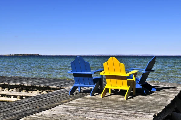 Καρέκλες σε ξύλινη αποβάθρα στη λίμνη — Φωτογραφία Αρχείου
