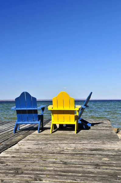 Cadeiras em doca de madeira no lago — Fotografia de Stock