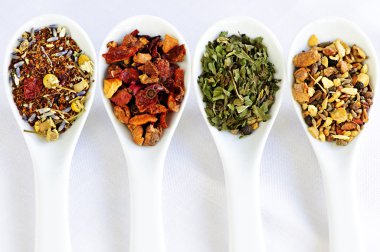Assorted herbal wellness dry tea in spoons clipart