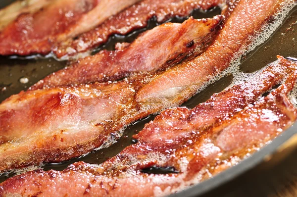 Bacon frying in a pan — Stock Photo, Image