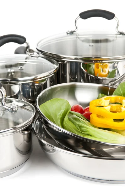 Stainless steel pots and pans with vegetables — Stock Photo, Image