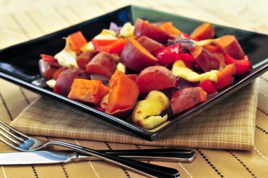 Vegetarian dish of roasted yams with cheese and peppers clipart