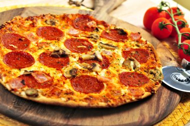 Freshly baked pepperoni pizza on wooden board clipart