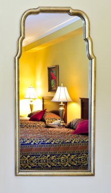 Bedroom interior reflected in mirror, image on the wall is my own. clipart