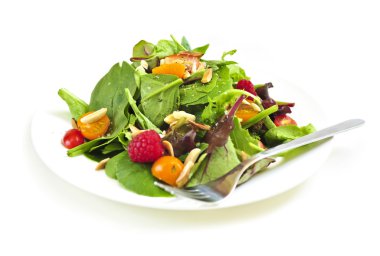 Plate of green salad on white background clipart