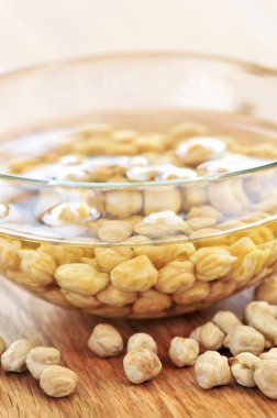 Dry raw chickpeas soaking in water before cooking clipart