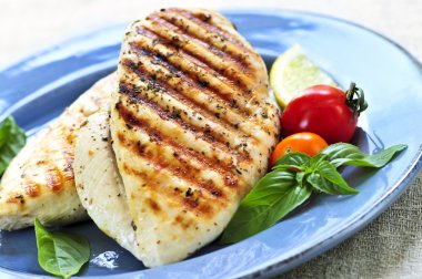 Grilled chicken breasts on a plate with fresh vegetables clipart