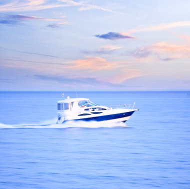 Speedboat at dusk, panning shot, in-camera motion blur clipart