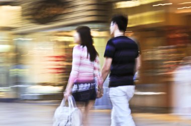 Çift, bir alışveriş merkezi içinde atış, panning kasıtlı kamera hareket bulanıklığı