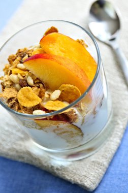 Serving of yogurt with fresh peaches and granola