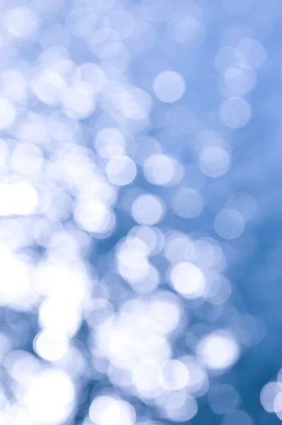 フォーカスの太陽の反射で青い水の背景のボケ味のうち クリスマスまたは冬の背景として使用することができます — ストック写真