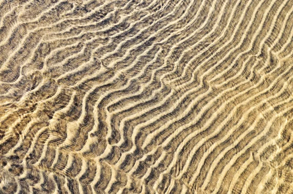 浅海域における砂の抽象的な自然背景波紋します — ストック写真