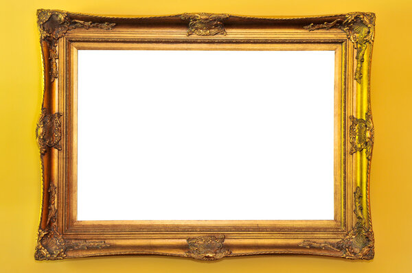 Empty gold picture frame on yellow wall