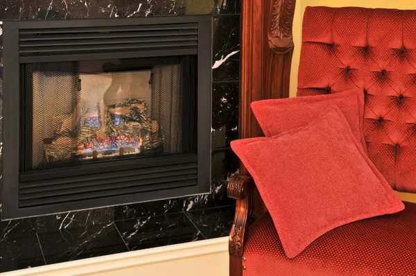 Fireplace and red chair — Stock Photo, Image