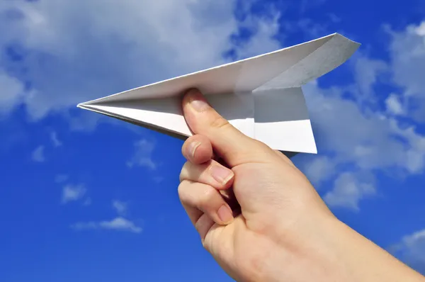 Рука держит бумажный самолет — стоковое фото