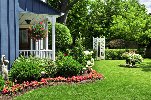 Landscaped front yard of a house with flowers and green lawn